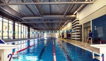 Eine große Schwimmhalle mit getrennten Bahnen und einer Aufsicht